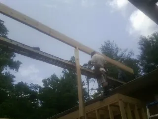 Carpenter setting a ridge beam over a new addition frame — Ice Dam Removal by Roofing Brothers in Custer City